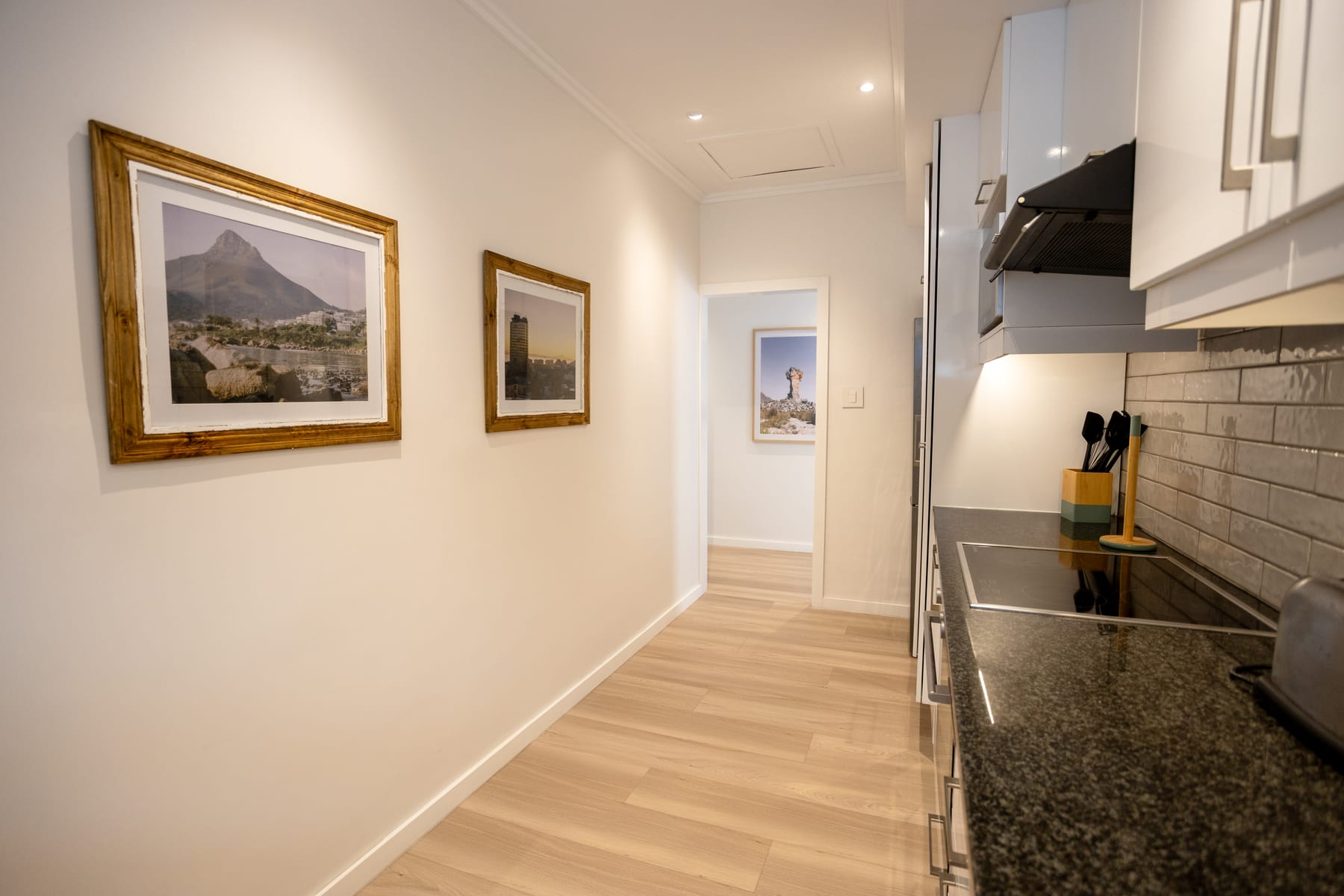 Kitchen cooking area with a hob and Cape Town artwork