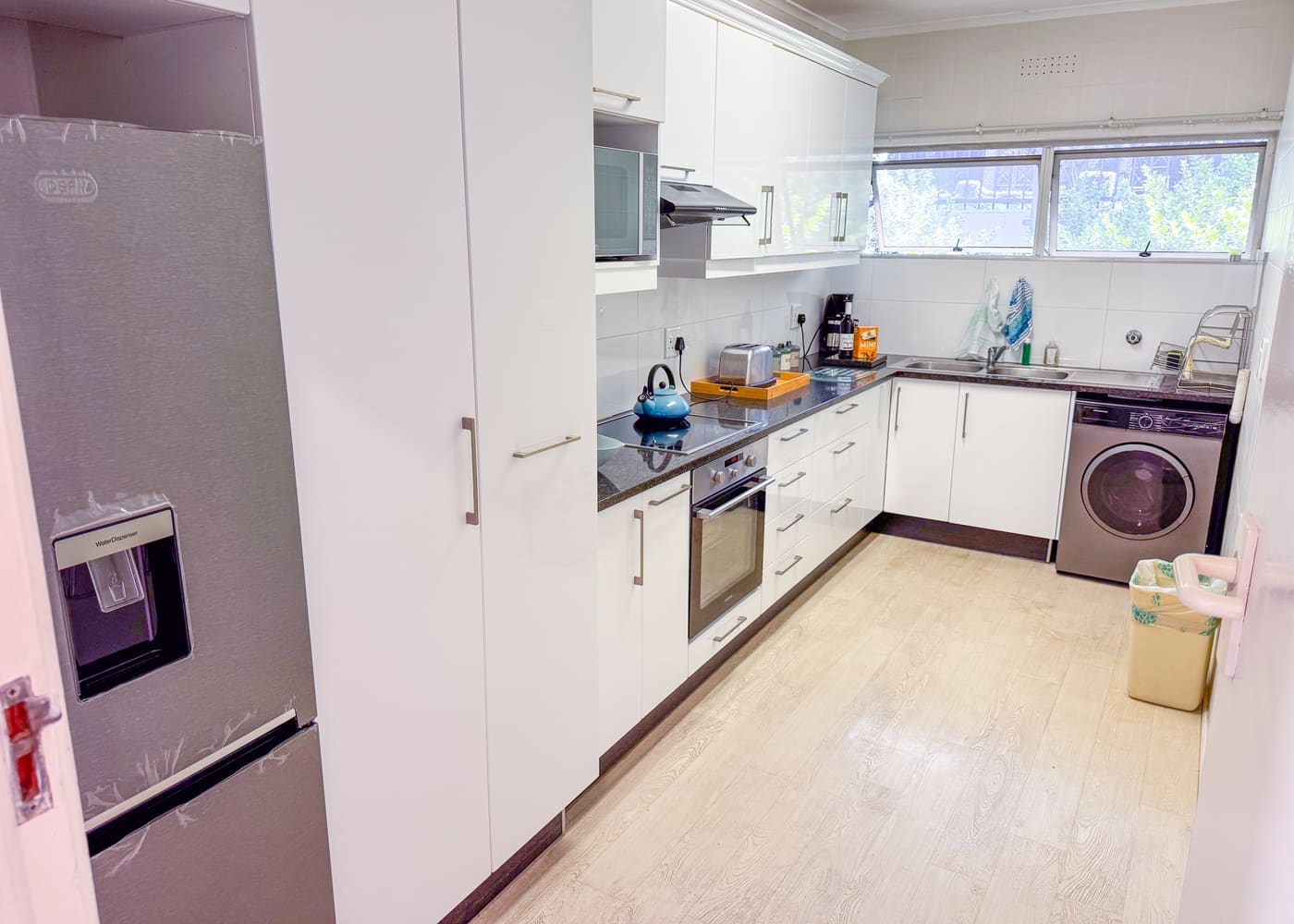 Kitchen with washing machine in the Green Point apartment