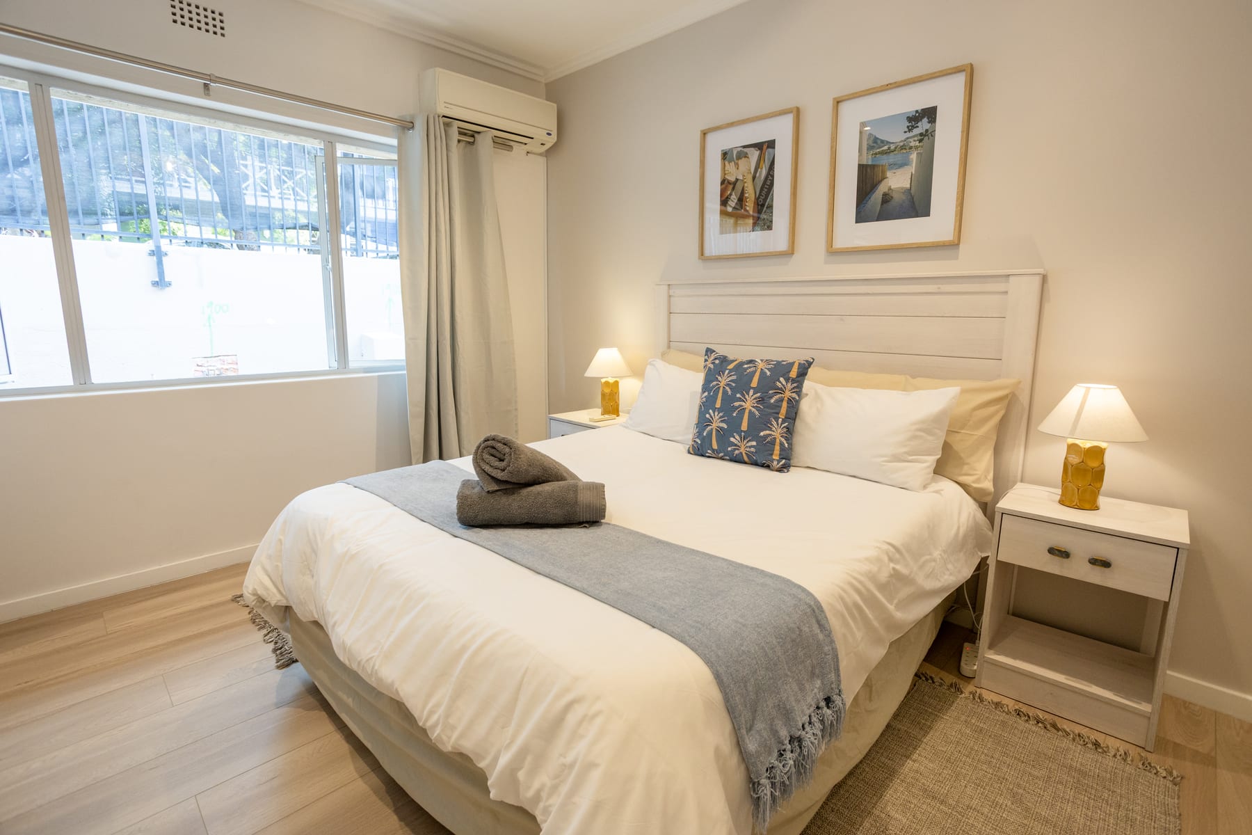 Queen bed with white linen and blue accents in the main bedroom