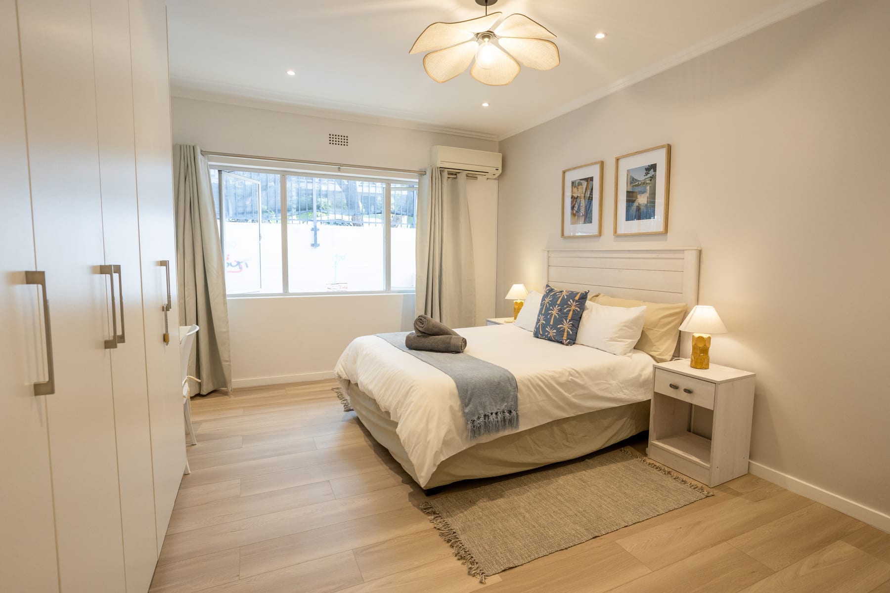 Main bedroom with built-in wardrobes, a large window and air conditioning