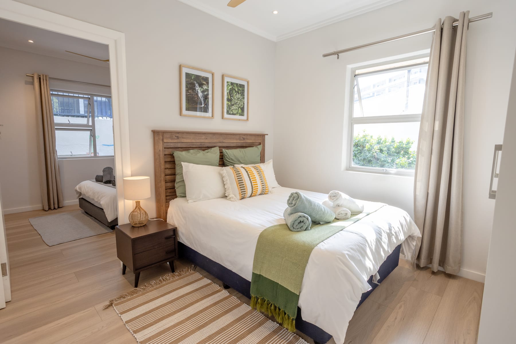 Second bedroom with green accents and a doorway to the third bedroom